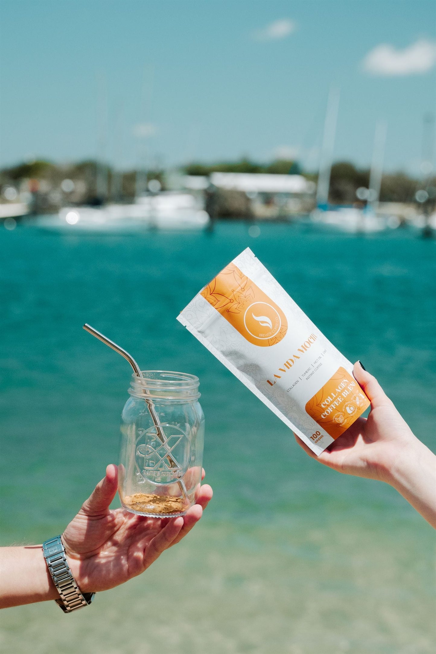 Brewdy collagen blend held over turquoise water