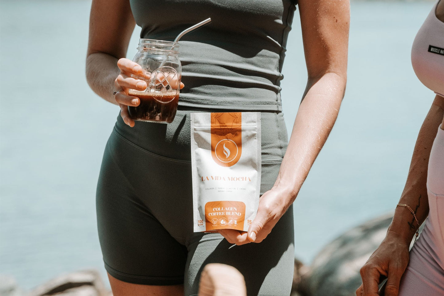 Women in activewear with iced coffee by the waterfront