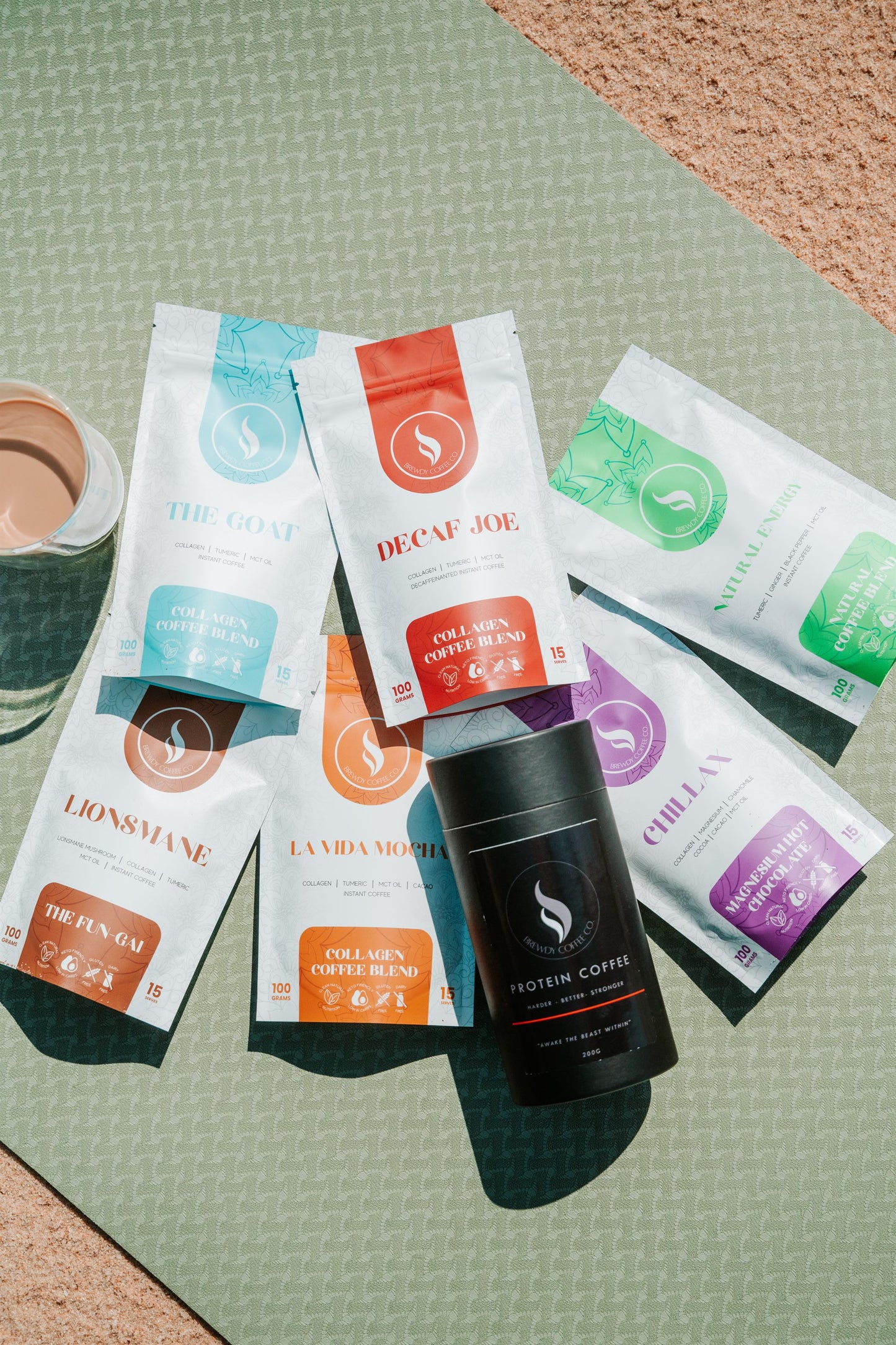 The full Brewdy functional coffee range laid out on a sage yoga mat